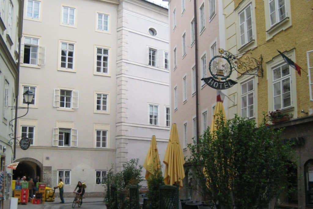 European hotel architecture with outdoor seating and historic building facades.