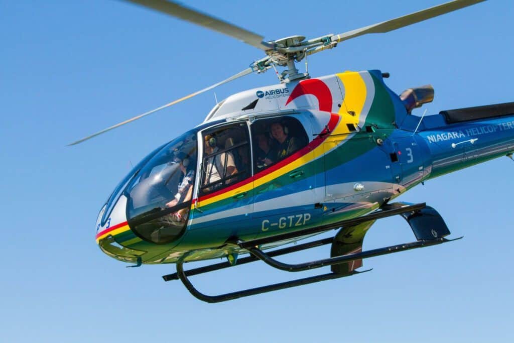 A colorful helicopter flying over Malaga for private sightseeing tours.