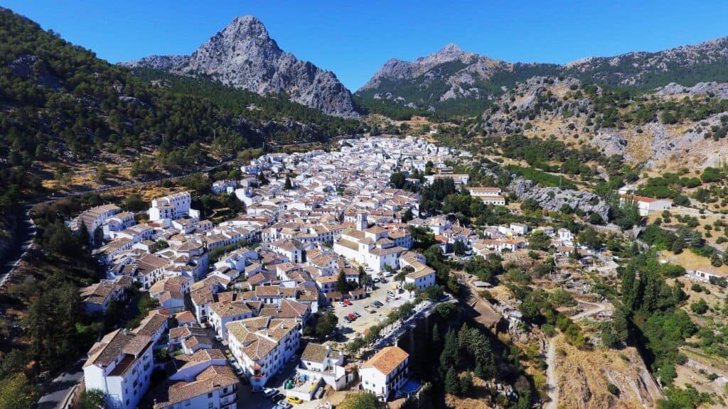 Beautiful aerial view of traditional whitewashed villages in Andalusia surrounded by mountains.