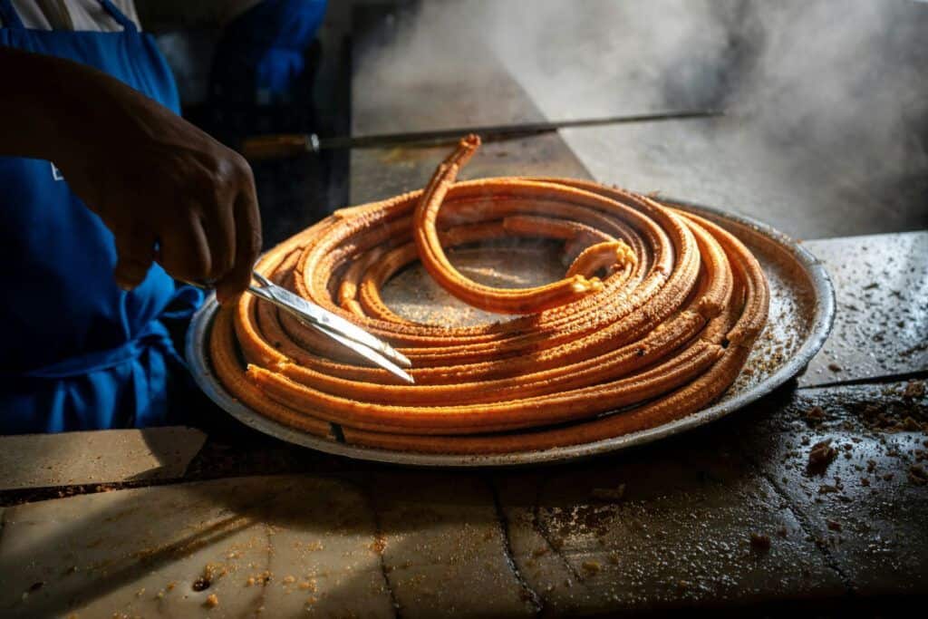 Authentic churros being prepared on a hot griddle in Malaga, perfect for churro lovers.