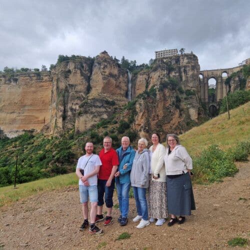 Group of tourists enjoying a scenic view of cliffs and waterfalls in Costa Excursions.