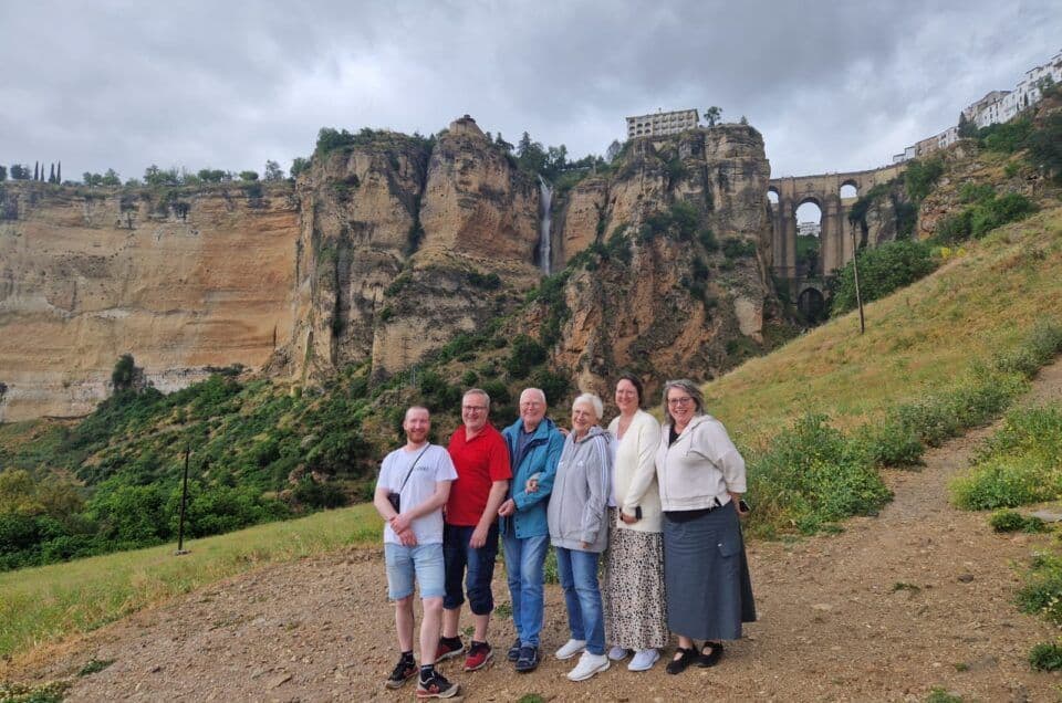 Group of tourists enjoying a scenic view of cliffs and waterfalls in Costa Excursions.