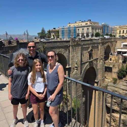 Family enjoying a sightseeing tour in Costa Excursions with historic bridge views.
