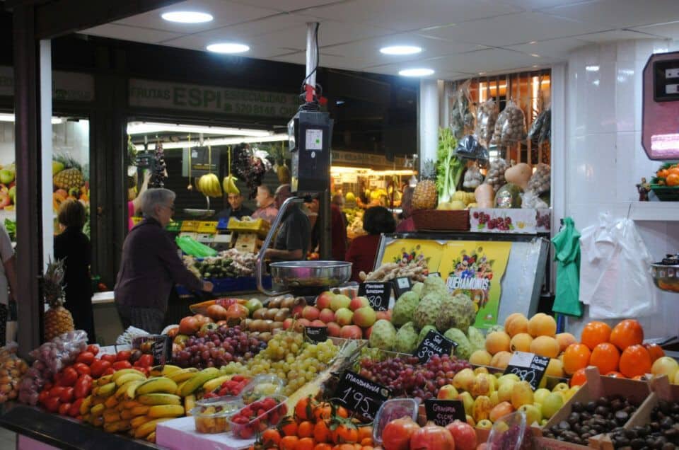 Vibrant local fruit market in Malaga showcasing fresh produce and colorful displays.
