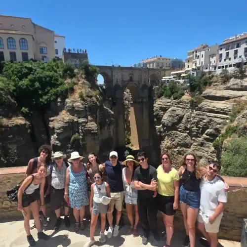 Tourists visiting Ronda Gorge in Spain with scenic views and historic bridges.