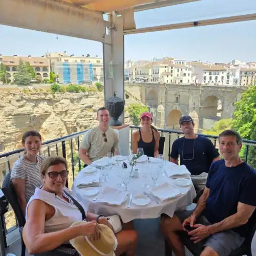 Outdoor dining with a group of friends overlooking historic cityscape.