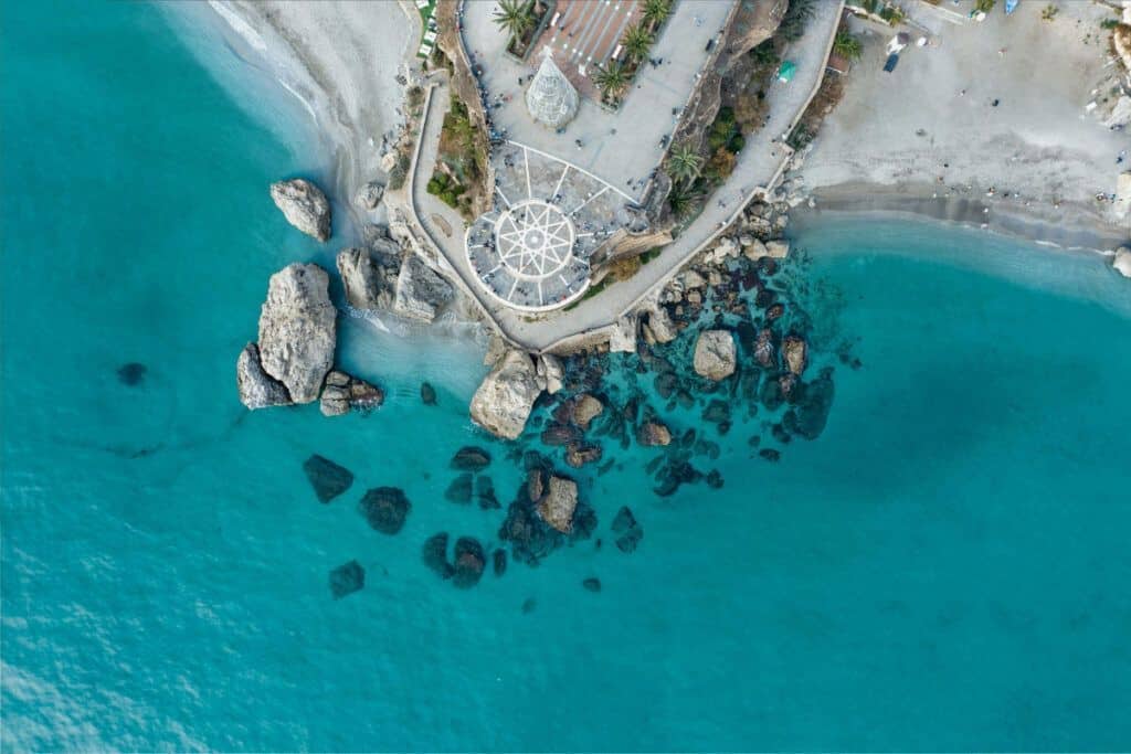 Aerial view of Nerja's rocky coastline and turquoise waters on the Costa del Sol.