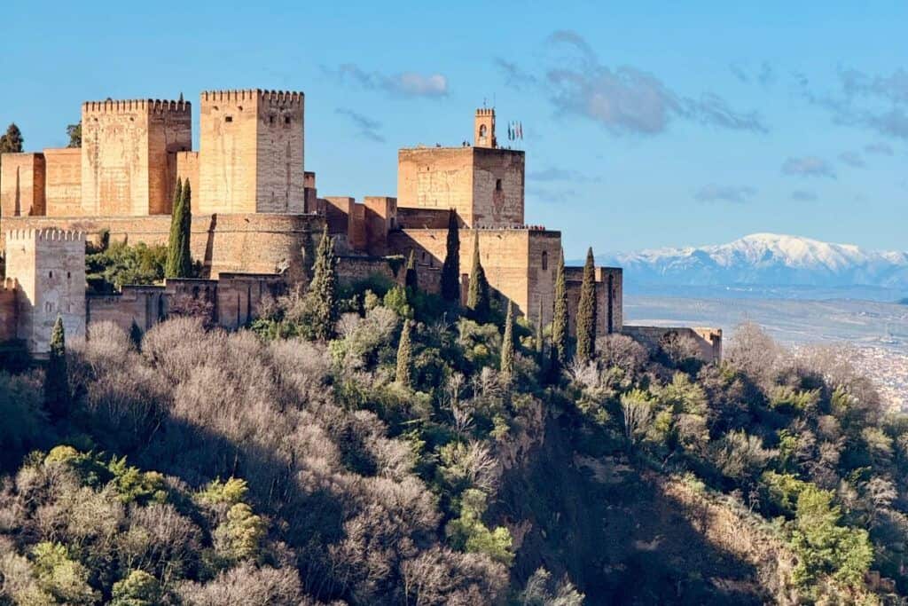 Alhambra Palace and Granada Medina with snow-capped mountains in the background.