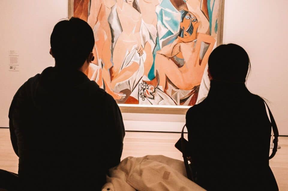 Visitors viewing Picasso artworks at Malaga Museum, cultural sightseeing in Spain.