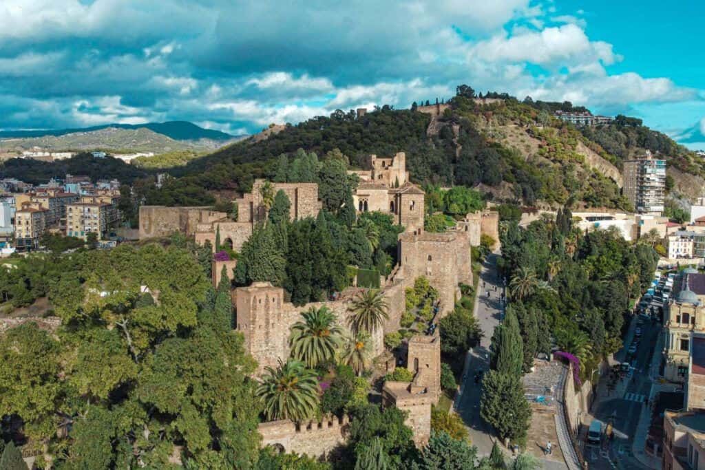Historic Moorish castle ruins in Málaga Old Town with lush greenery and city views.