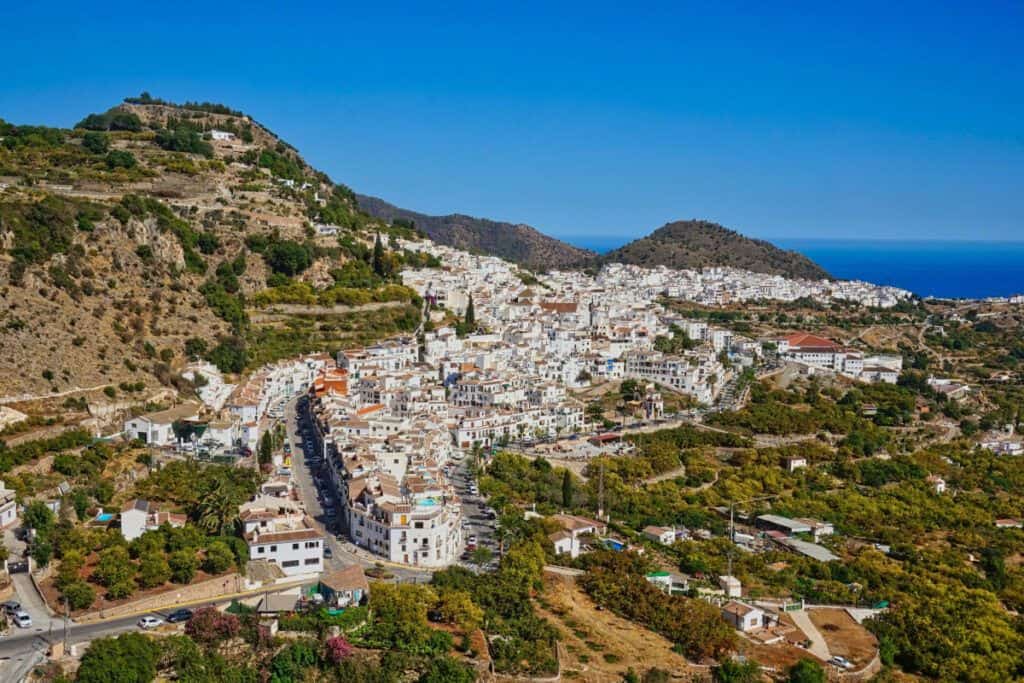 Scenic view of a coastal town with white buildings and surrounding hills in Costa del Sol.