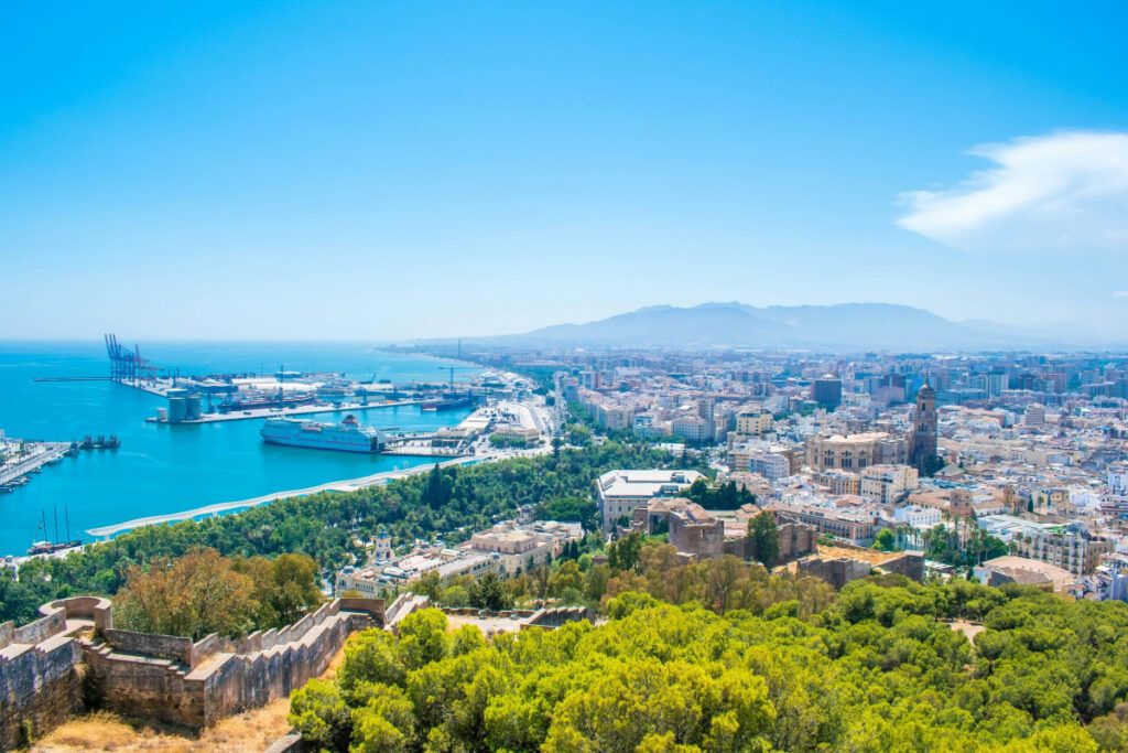 Panoramic view of Málaga's coastline, port, and cityscape from the historic hilltop.